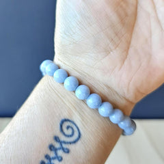 Angelite crystal bracelet worn on wrist, handmade design promoting calm communication.