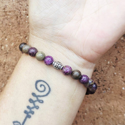 Atlantisite bracelet on arm, natural gemstone jewellery for men and women seeking wisdom and peace.