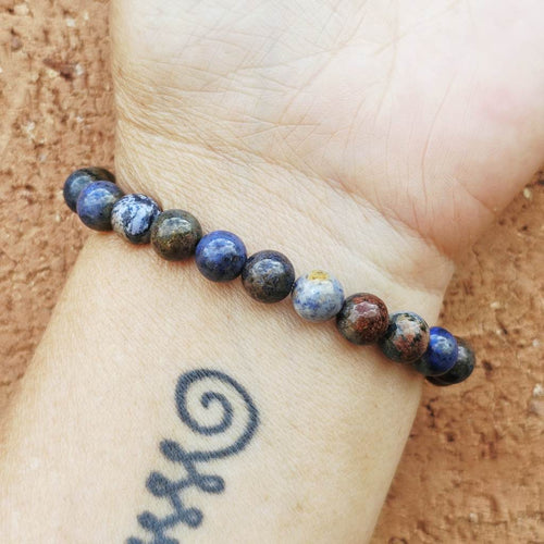 Blue Dumortierite gemstone bracelet on wrist for peace and balance.