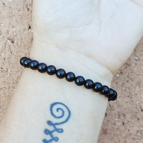 Obsidian beaded bracelet with elephant charm symbolising wisdom and power.