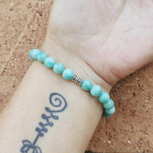 Close-up of Amazonite bracelet on arm, handmade design for calm communication and heart connection.