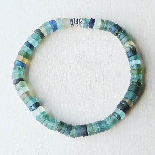 Close-up of Ancient Roman Glass beads showing iridescent tones shaped by centuries underground.