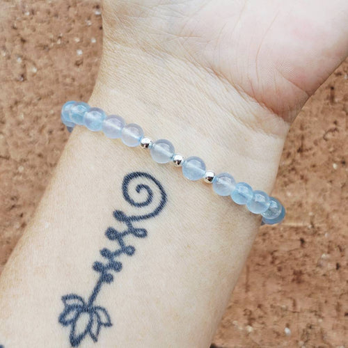 Aquamarine crystal bracelet worn on wrist, handmade design for clear communication and calm focus.