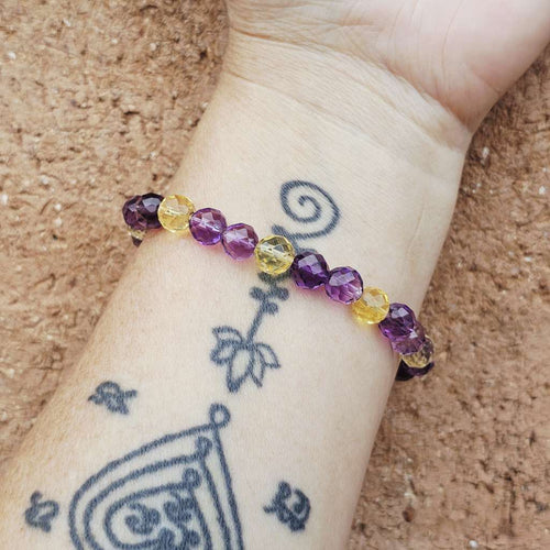 Amethyst and Citrine faceted bracelet on wrist for joy and wisdom.