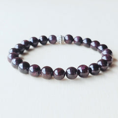 Garnet stone bracelet balancing Root and Heart Chakras for stability.