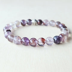 Rare seven-mineral Super 7 bracelet showcasing inclusions of rutile, lepidocrocite, cacoxenite.