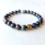 Handmade Tiger’s Eye Trio bracelet uniting red, brown, and blue stones for chakra balance.